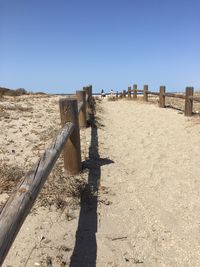 Shadow of people on beach against clear sky