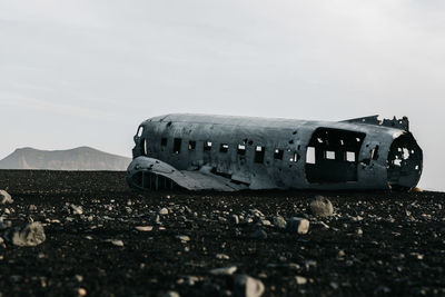 Abandoned airplane on land against sky