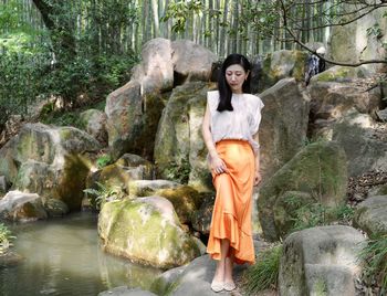 Portrait of young woman standing in forest