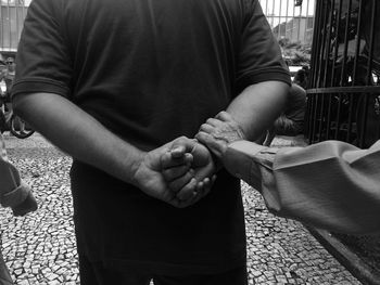 Mid section of a man with hands clasped