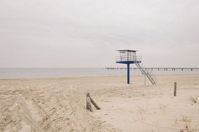 Lifeguard hut at beach against sky