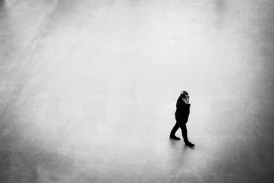 High angle view of businessman talking on phone while walking at town square