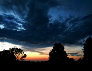 Silhouette of trees against cloudy sky