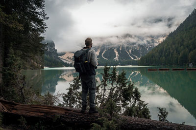 Man standing by lake against mountains