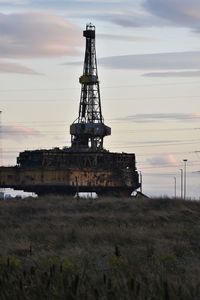 Traditional windmill on field against sky during sunset