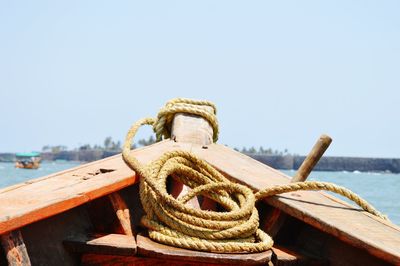 Rope on boat in sea against clear sky