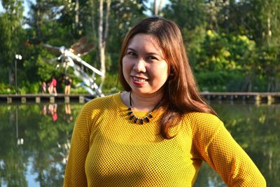 Portrait of smiling woman by pond