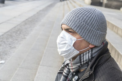 Midsection of man with umbrella on street in winter