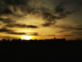 Scenic view of silhouette landscape against orange sky