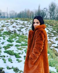 Portrait of young woman standing on snow