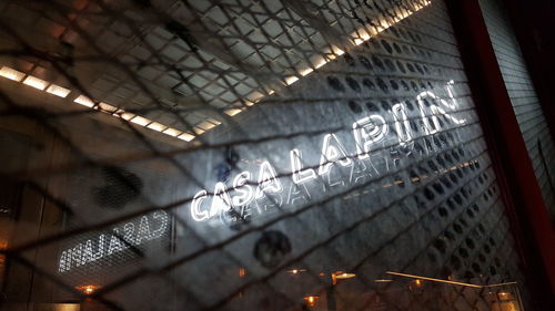 Low angle view of illuminated text on metal railing