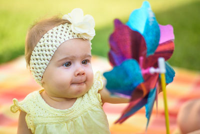 Cute girl looking at pinwheel toy