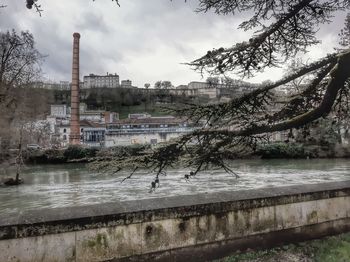 River by buildings against sky