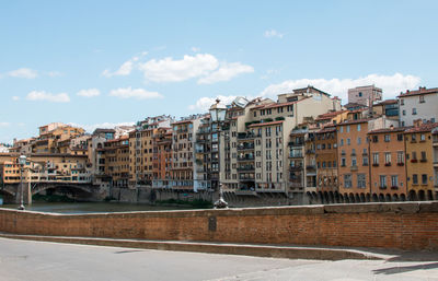 Buildings in city against cloudy sky