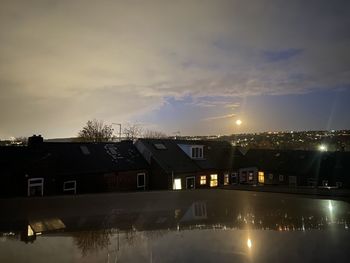 Illuminated buildings against sky at night