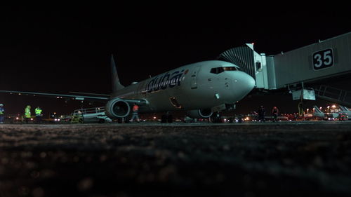 Airplane on airport runway against sky at night