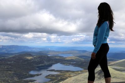 Man standing on rock against sky