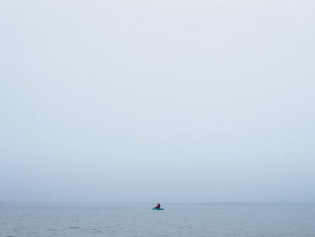 Man sailing on sea against sky