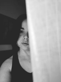 Close-up portrait of woman looking through window