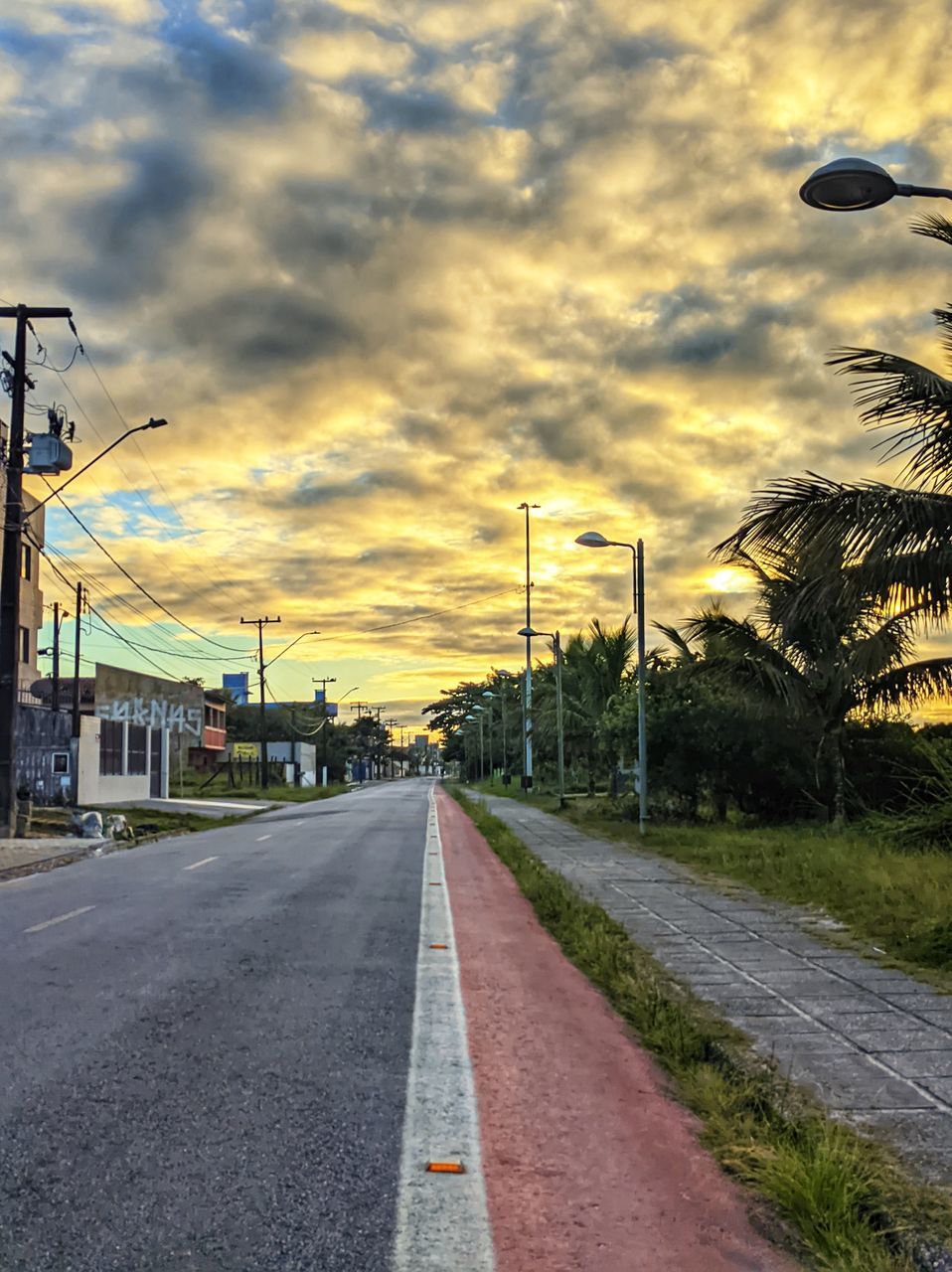 road, sky, cloud, transportation, street, city, the way forward, nature, architecture, morning, street light, sign, no people, built structure, infrastructure, diminishing perspective, lane, building exterior, vanishing point, tree, urban area, outdoors, road marking, mode of transportation, marking, symbol, road surface, plant, sunlight, dramatic sky, car, travel destinations