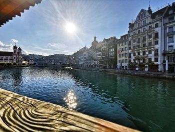 Buildings by lake against sky in city