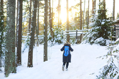 Full length rear view of man on snow covered land