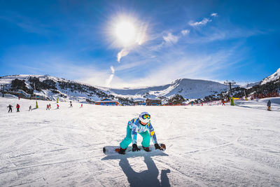 Woman, falling down when learning how to ride on a snowboard andorra