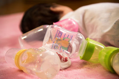 Baby with milk bottle lying down indoors