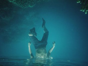 Low section of man swimming in sea