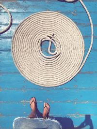 Low section of woman standing by spiral rope arranged on boat