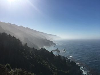 Scenic view of sea and mountains against sky