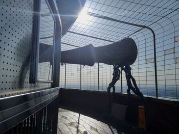 Shadow of person on railing against sky seen through window