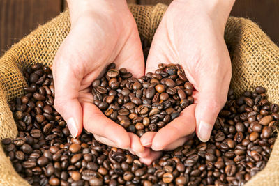Close-up of hand holding coffee beans