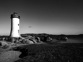 Lighthouse by sea against sky