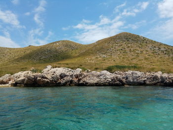 Scenic view of sea and mountains against sky