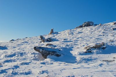 View of snow on mountain against clear blue sky