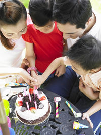 Family celebrating birthday in lawn