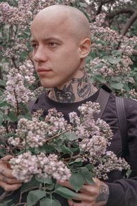 Portrait of woman with pink flowers against plants