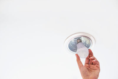 Midsection of man holding glass over white background