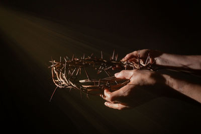 Closeup crown of thorns in hands and sun rays
