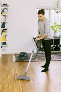 Woman holding camera at home