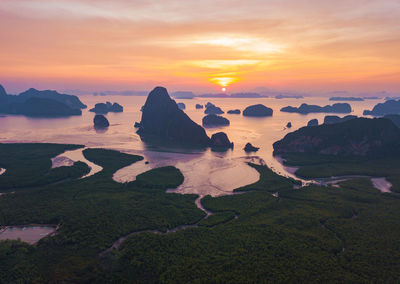 Scenic view of rocks in sea against sky during sunset