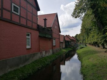 Canal amidst buildings against sky