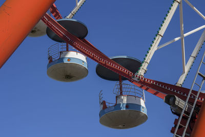 Low angle view of ferris wheel against clear blue sky