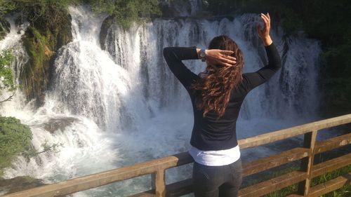 Woman standing by waterfall