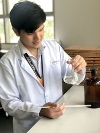 Female dentist examining chemical at home