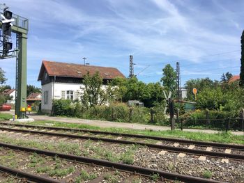 Railroad tracks by buildings against sky