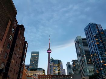 View of buildings in city against cloudy sky