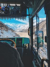 Panoramic view of snowcapped mountains seen through train window