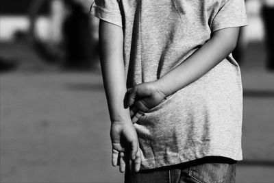 Midsection rear view of boy standing on footpath